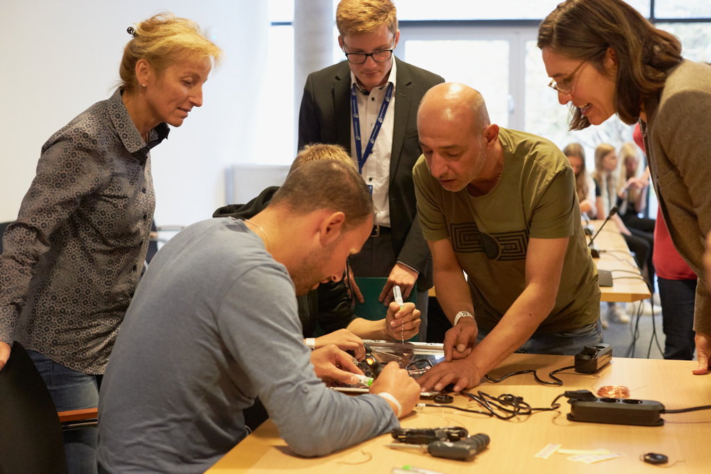 Nihad Dabeet leitet das Ausschneiden der Blätter an, Workshop im Erfurter Landtag im Rahmen des Achava Schülerforums, September 2019